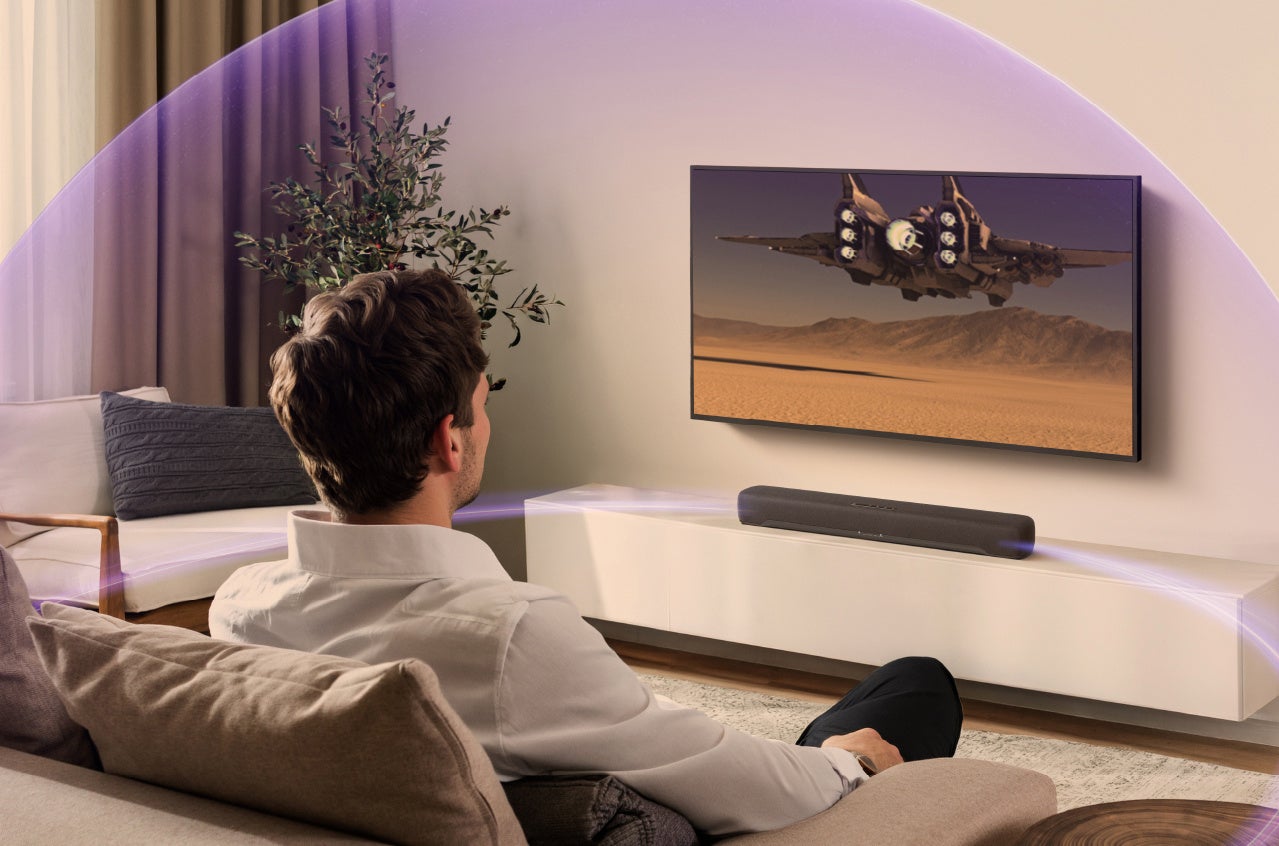 リビングのテレビ下に置かれたサウンドバーから音波がドーム状に広がる様子を示したイメージ