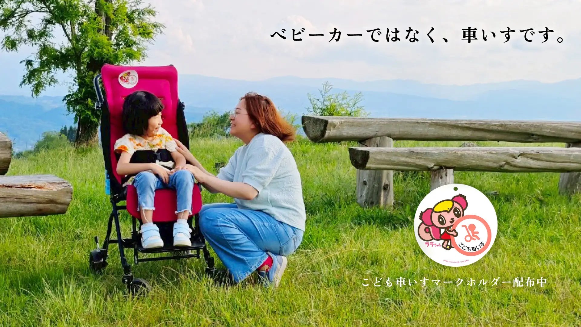 芝生の上で子ども用車いすに乗る子どもと見守る保護者、右下にマークホルダーのグラフィック