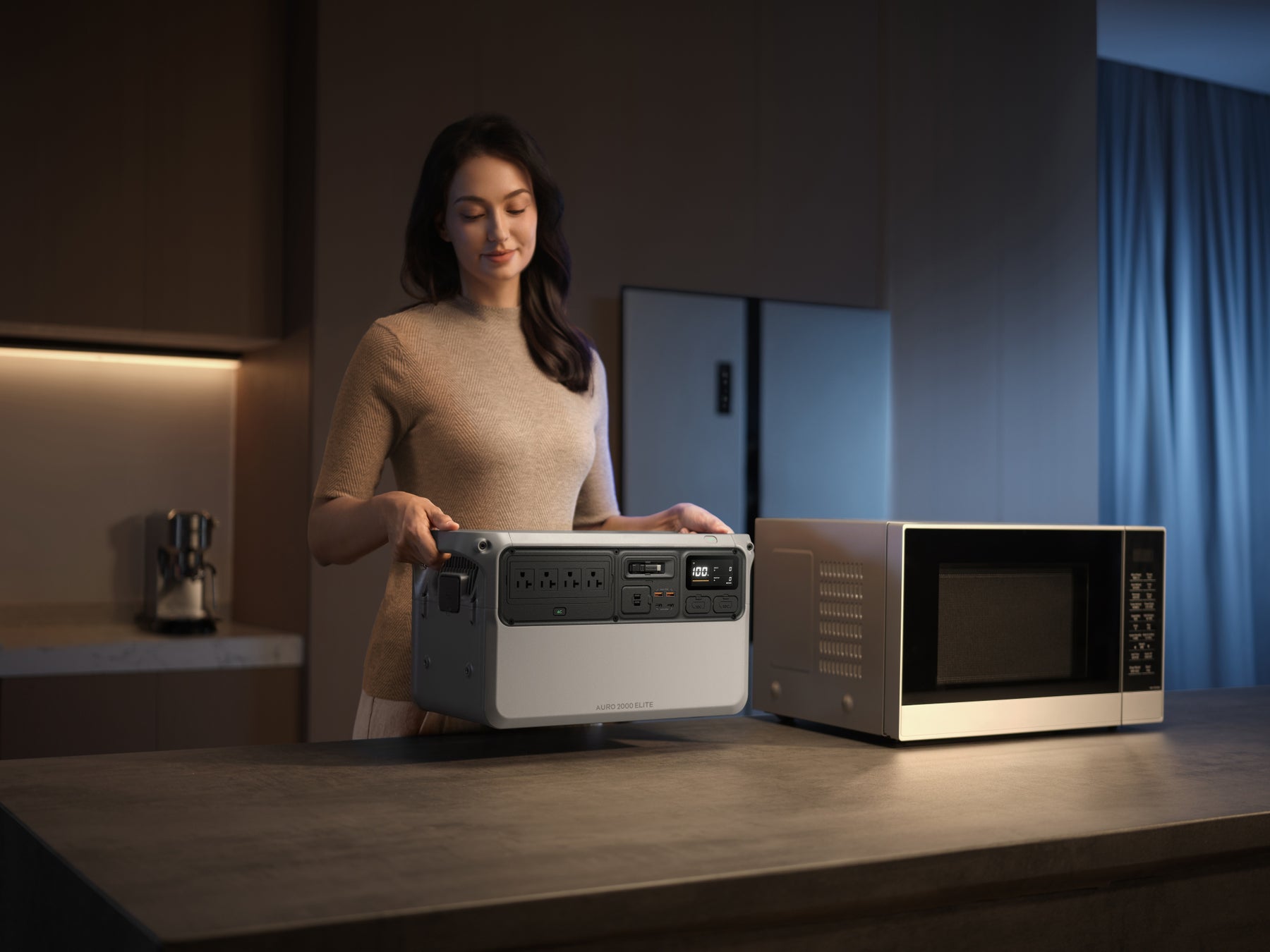 室内で女性が電子レンジの横にポータブル電源を持ち運んで置こうとしている様子の写真。