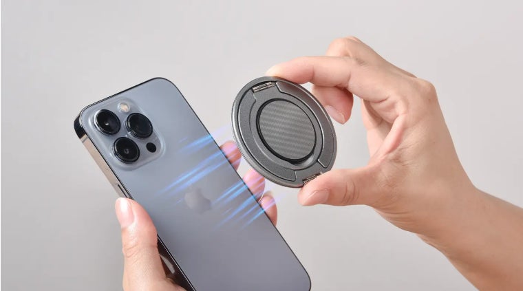 スマートフォンの背面マグネット位置にスマホリングを近づけて装着する様子