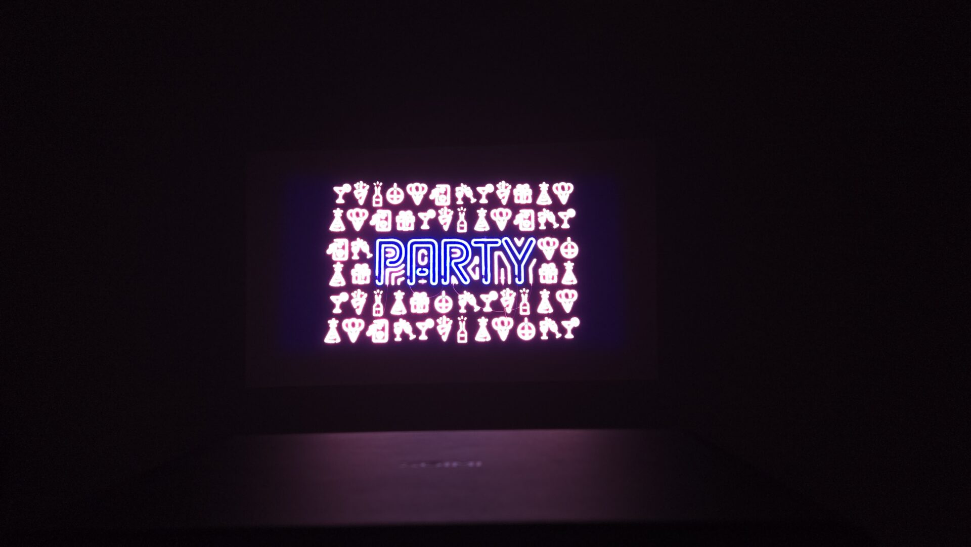 真っ暗な背景に青いネオンでPARTYの文字とピンクのネオンでカクテルグラスや王冠などのパーティーシンボル