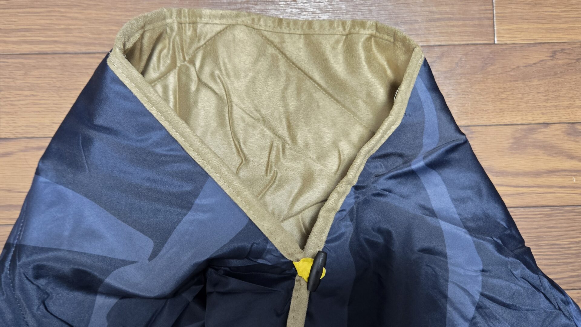 紺色の模様入り表地と茶色のふわふわ裏地のリバーシブル毛布留め具付き