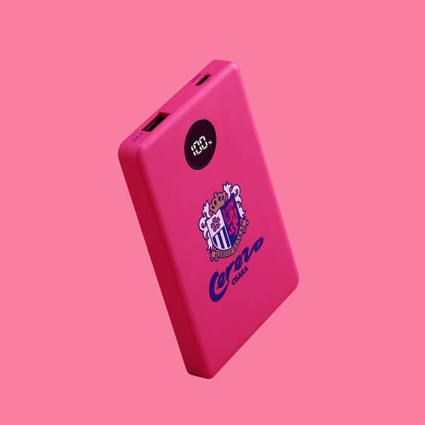 ピンク色の薄型モバイルバッテリーの外観写真。表面にエンブレムやロゴ、残量表示部が配置されている。