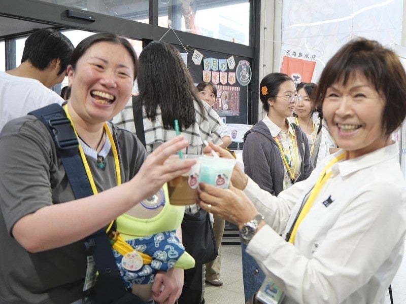 飲み物を手に笑顔を見せる参加者の写真