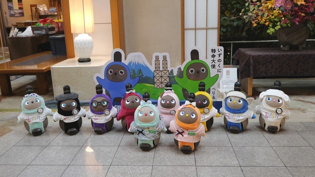 パネルの前に並んだ複数の小型ロボットの写真