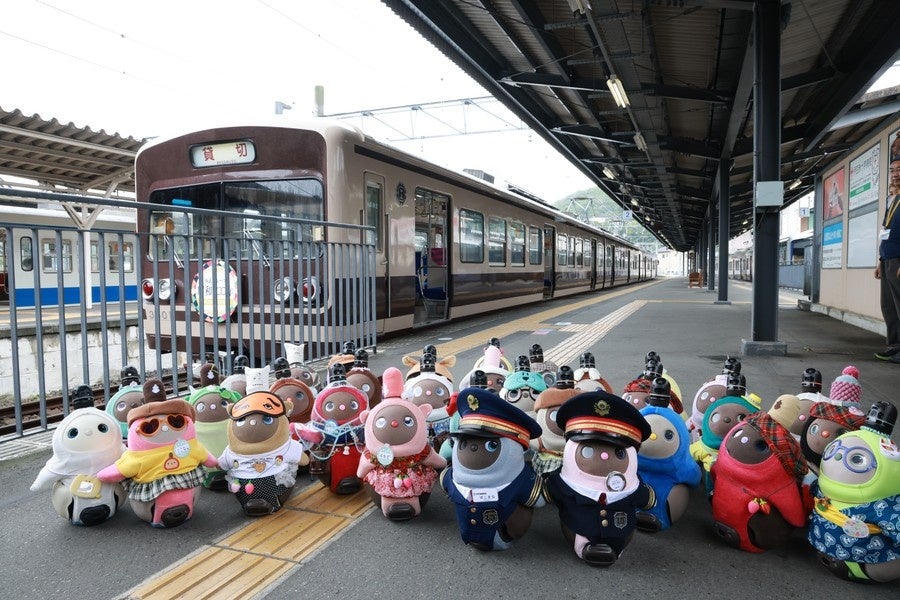駅ホームの列車前に並ぶ多数の小型ロボットの写真