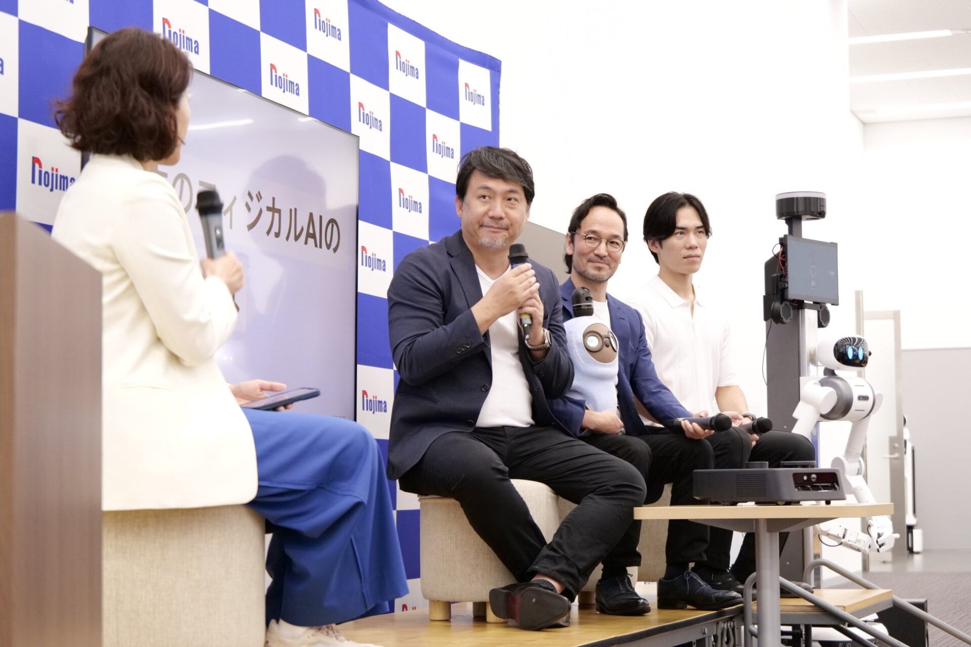 登壇者4名と脇に配置されたロボットが並ぶセッション風景