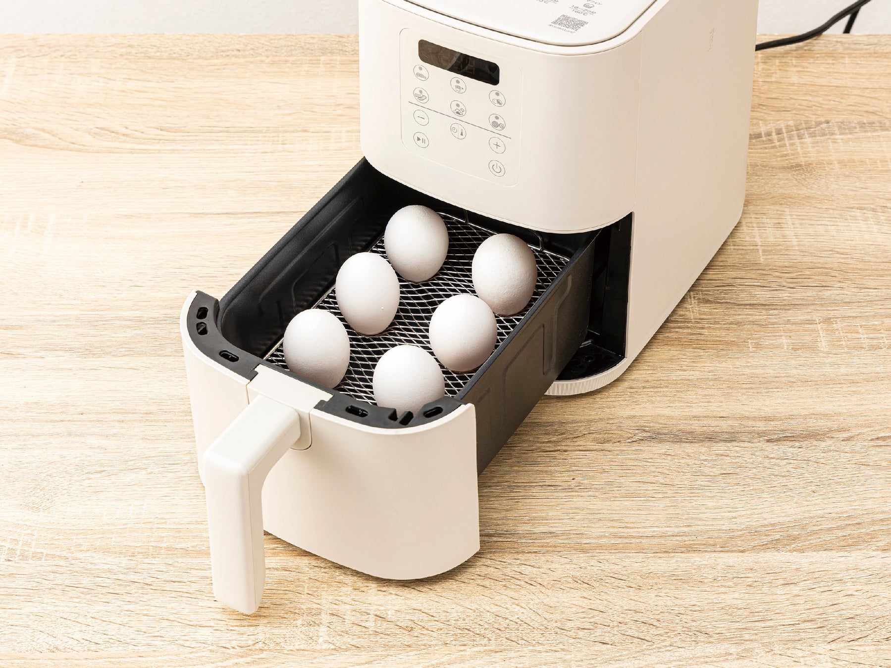 引き出された調理トレイの網の上に卵が並べられている様子