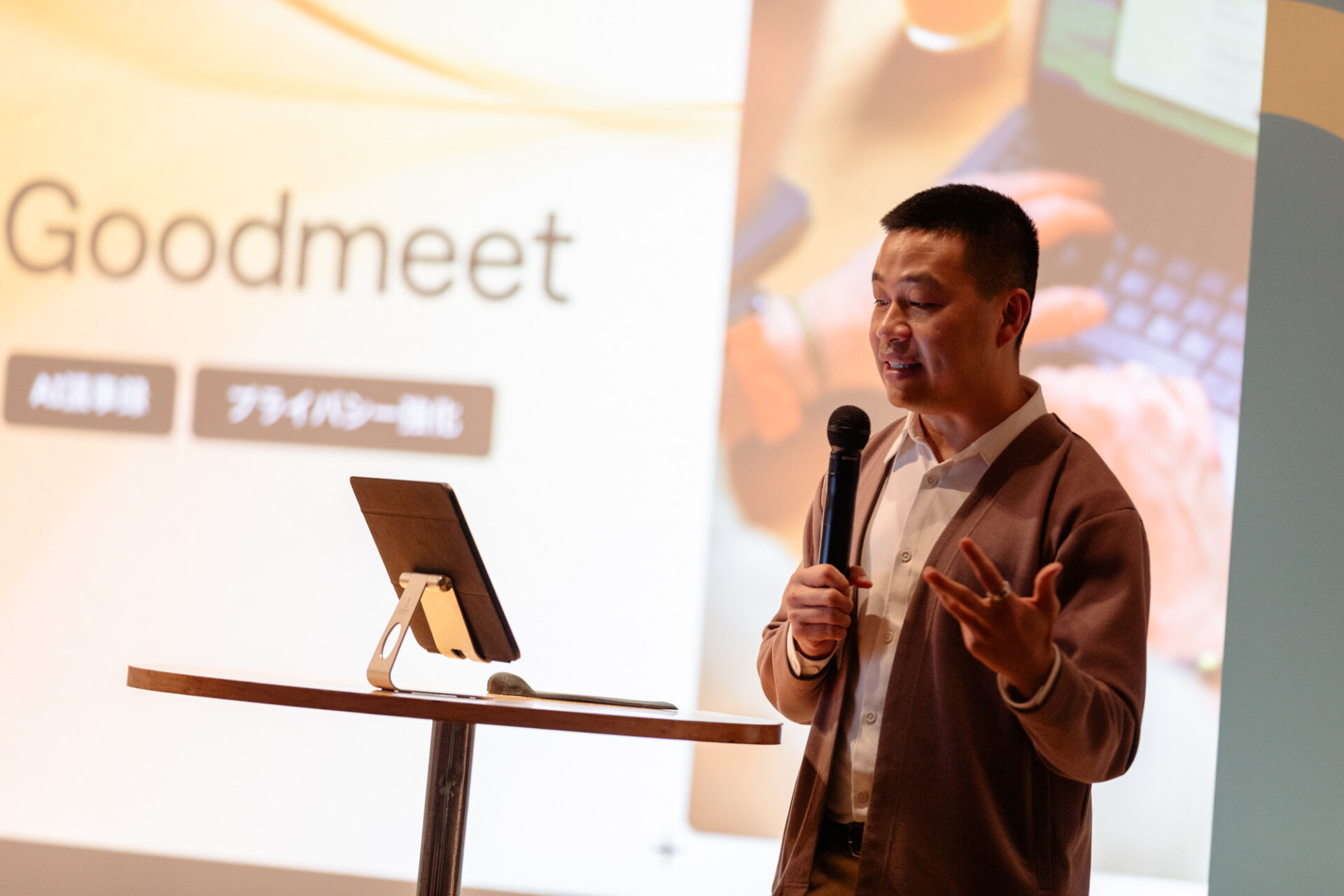 Goodmeetの紹介画面と登壇するミン・トラン氏