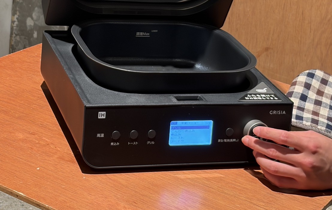 GRISIAの前面ダイヤルに指を添える手元と青い液晶