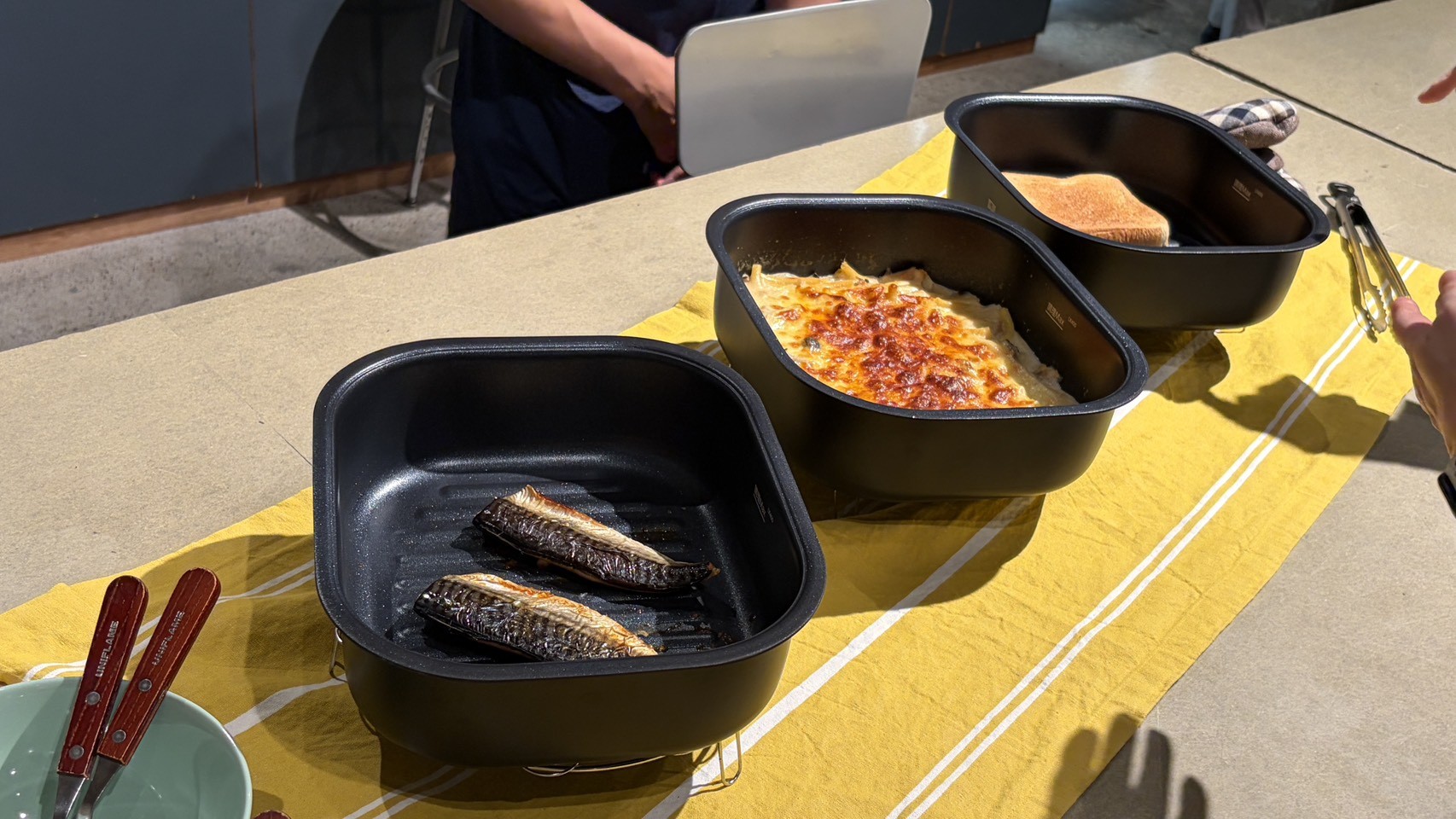 魚、表面に焼き色がついた料理、トーストを入れた3つのポット