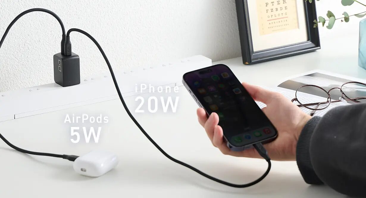 黒い充電器でiPhone20ワットとAirPods5ワットを同時に充電する様子