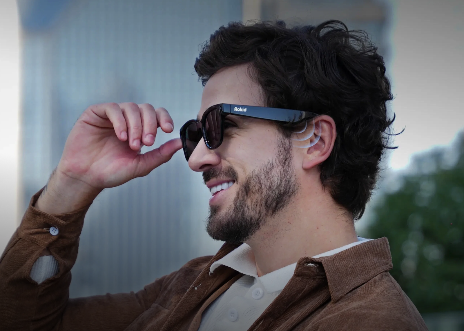 男性がRokid Ai Glasses Styleを装着し、右手でフレームに触れている提供写真