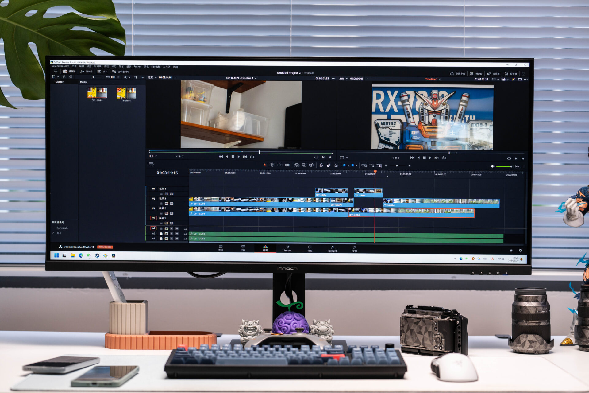 映像編集ソフトDaVinci Resolveが映るモニターとデスク周りの様子 画面にはタイムラインや棚の動画 ガンダムの画像が見える デスク上にはキーボード マウス スマートフォン カメラとレンズ 悪魔の実やシーサーの置物が並ぶ